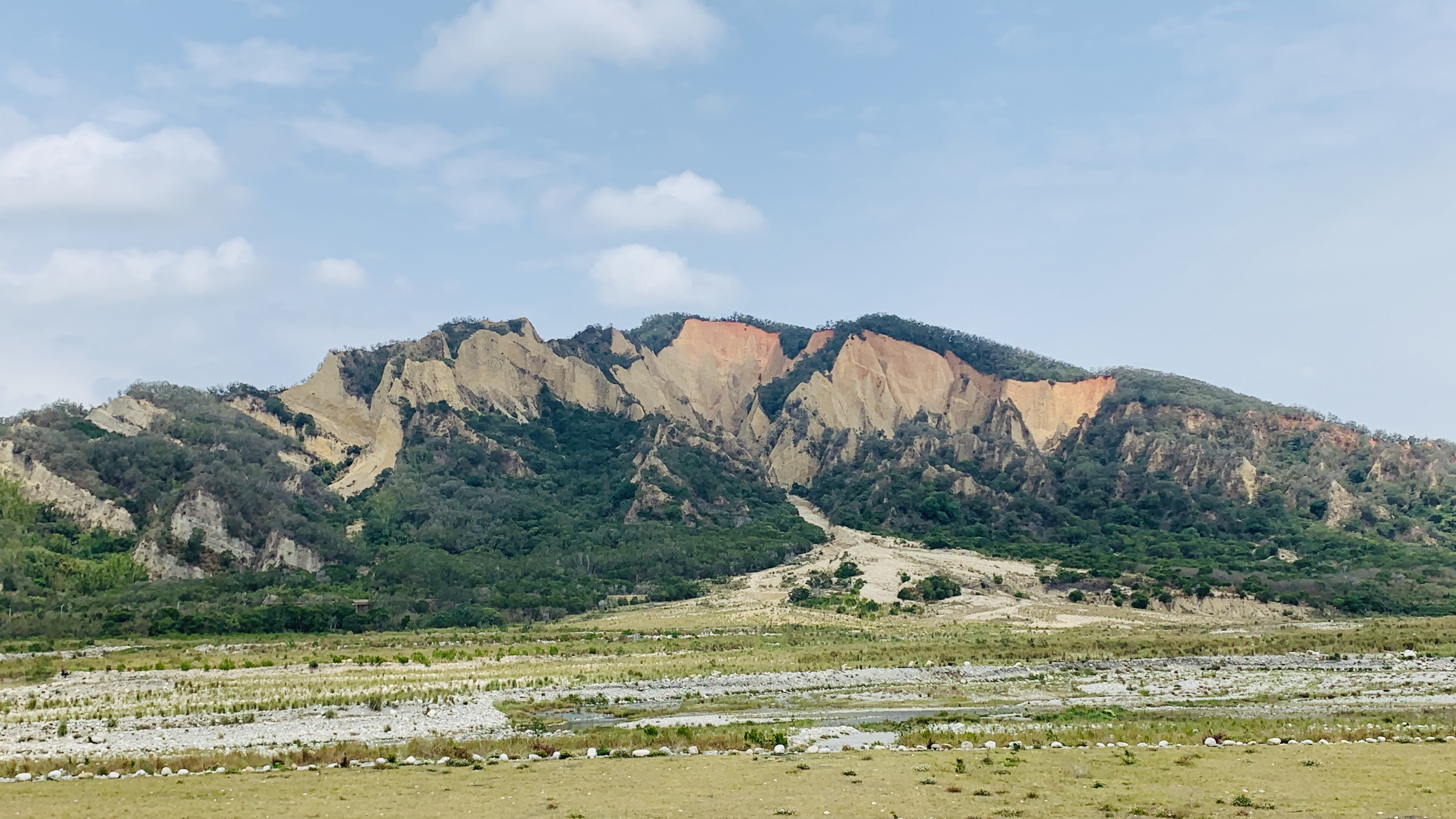 | Sanyi–Tai'an: Slow ride, distant views of the Flaming Mountain badlands | Along Taiwan’s West Coast Mountain Line, gaze from the train at Huoyanshan’s rare terrain—undulating red-soil and gravel cliffs. Under the blazing sun the whole mountain glows crimson. Passing here, don’t miss this majestic natural masterpiece.